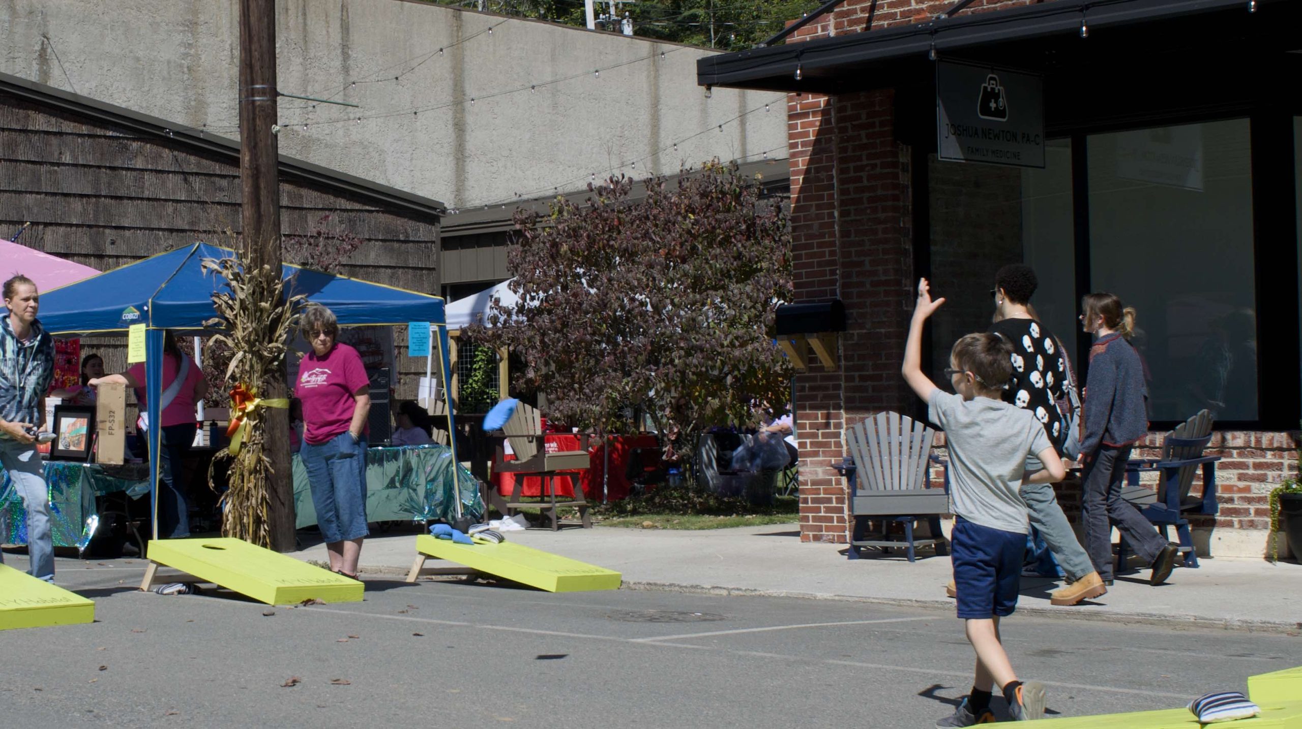 Child playing Corn Hole in downtown Spruce Pine