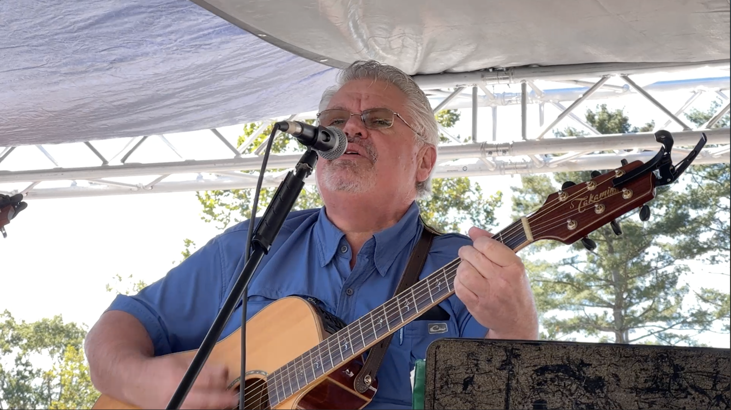 Musician holding guitar performing bluegrass music